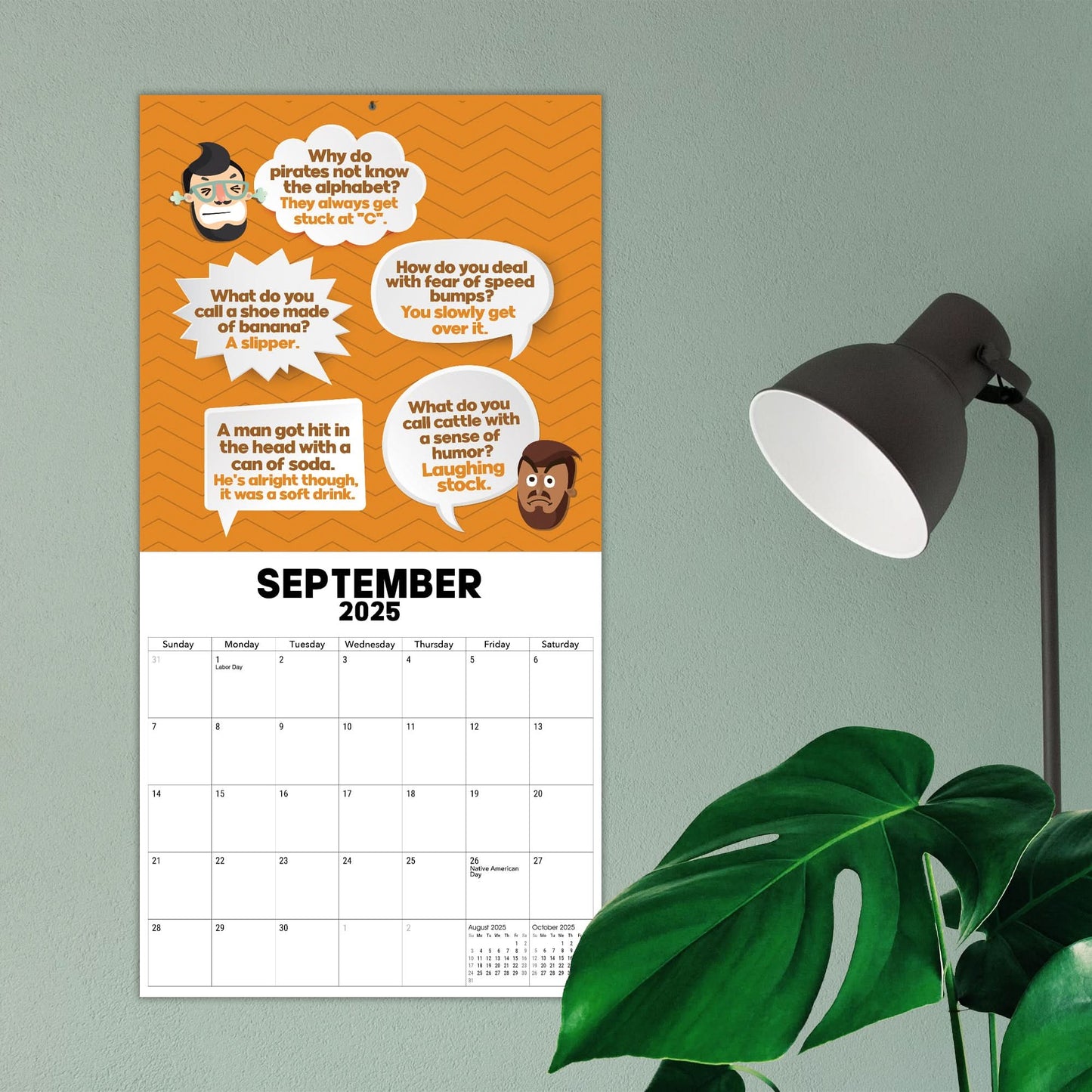 A 2025 Dad Joke Wall Calendar from That Is So Dad, brimming with puns and dad humor for September 2025, accompanied by a green plant and white lamp, makes the perfect comedy gift.