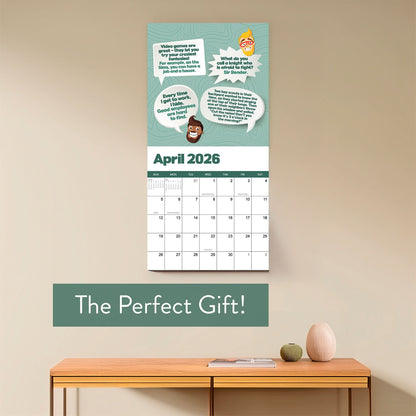 The 2026 Dad Joke Wall Calendar by That Is So Dad, with cartoon faces and witty quotes, hangs above a shelf with a vase, bowl, and small book. Text below says: “The Perfect Gift!”.