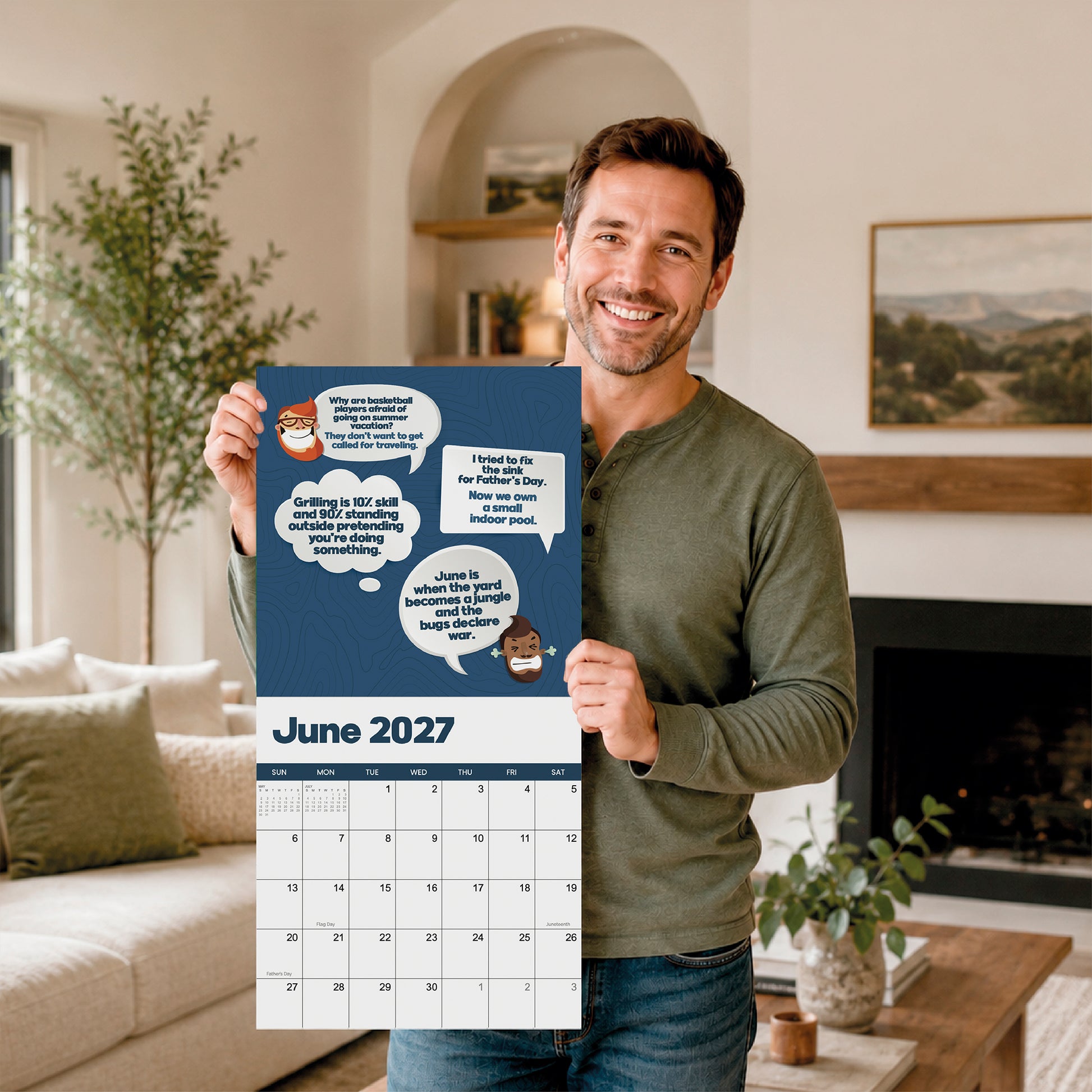A smiling man stands in a living room holding the 2027 Dad Joke Wall Calendar by That Is So Dad, which features cartoon characters and speech bubbles filled with hilarious puns.