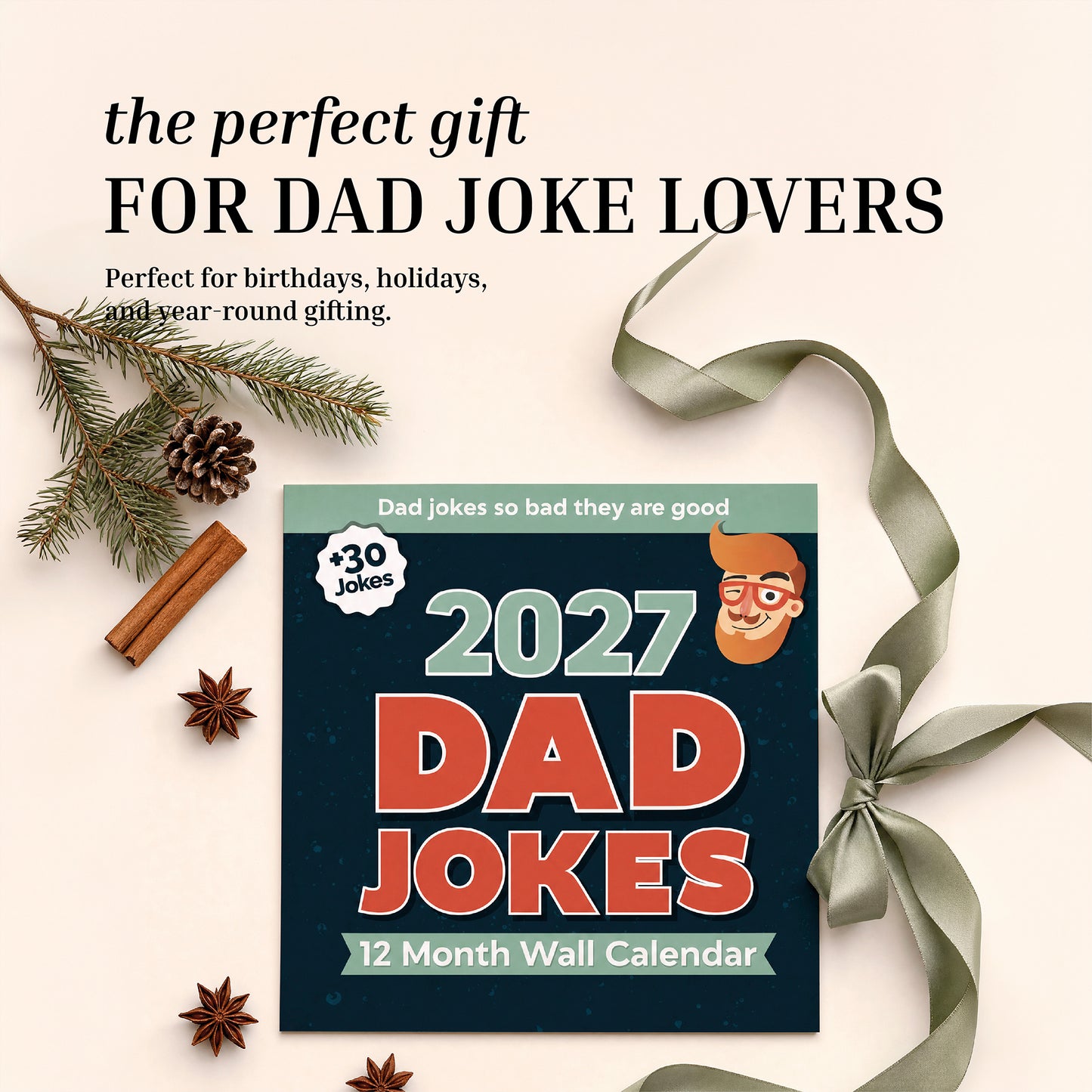 The 2027 Dad Joke Wall Calendar by That Is So Dad rests on a beige surface, surrounded by ribbon, pine branches, cinnamon sticks, and star anise. Above the calendar, text highlights this funny calendar as the perfect gift for anyone who loves dad jokes.