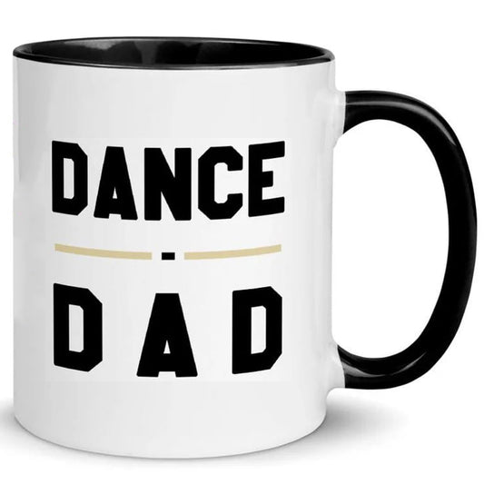 The Dance Dad Mug by That Is So Dad is a white ceramic mug with a black handle, showcasing "DANCE DAD" in bold black letters separated by a gold line. Dishwasher and microwave safe for convenience.