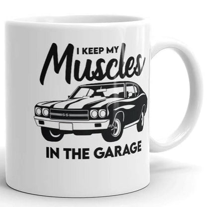 The Muscle In The Garage Mug by That Is So Dad is a white ceramic mug featuring a classic muscle car illustration and the phrase "I keep my muscles in the garage." Microwave safe, it’s perfect for car enthusiasts.