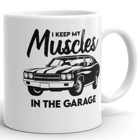 The Muscle In The Garage Mug by That Is So Dad is a white ceramic mug featuring a classic muscle car illustration and the phrase "I keep my muscles in the garage." Microwave safe, it’s perfect for car enthusiasts.