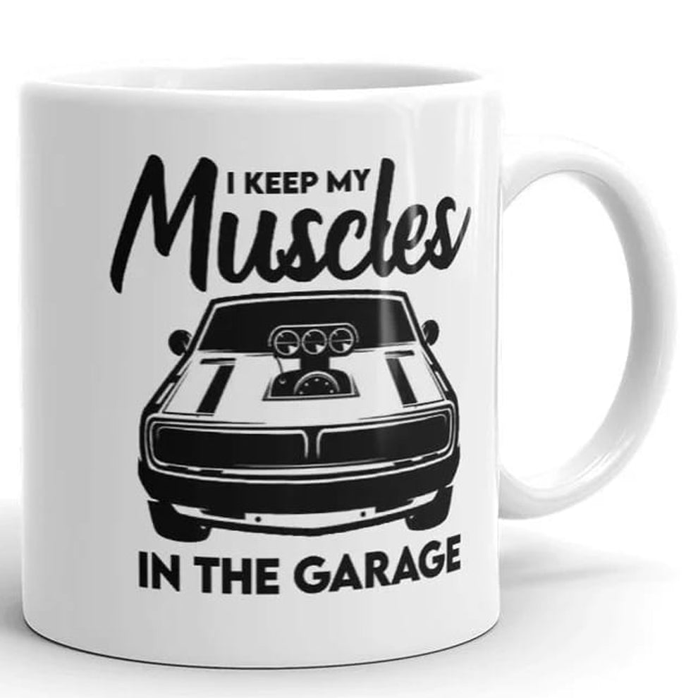 The Muscle In The Garage Mug by That Is So Dad features a black muscle car design and the phrase "I keep my muscles in the garage." Dishwasher safe for easy cleaning.